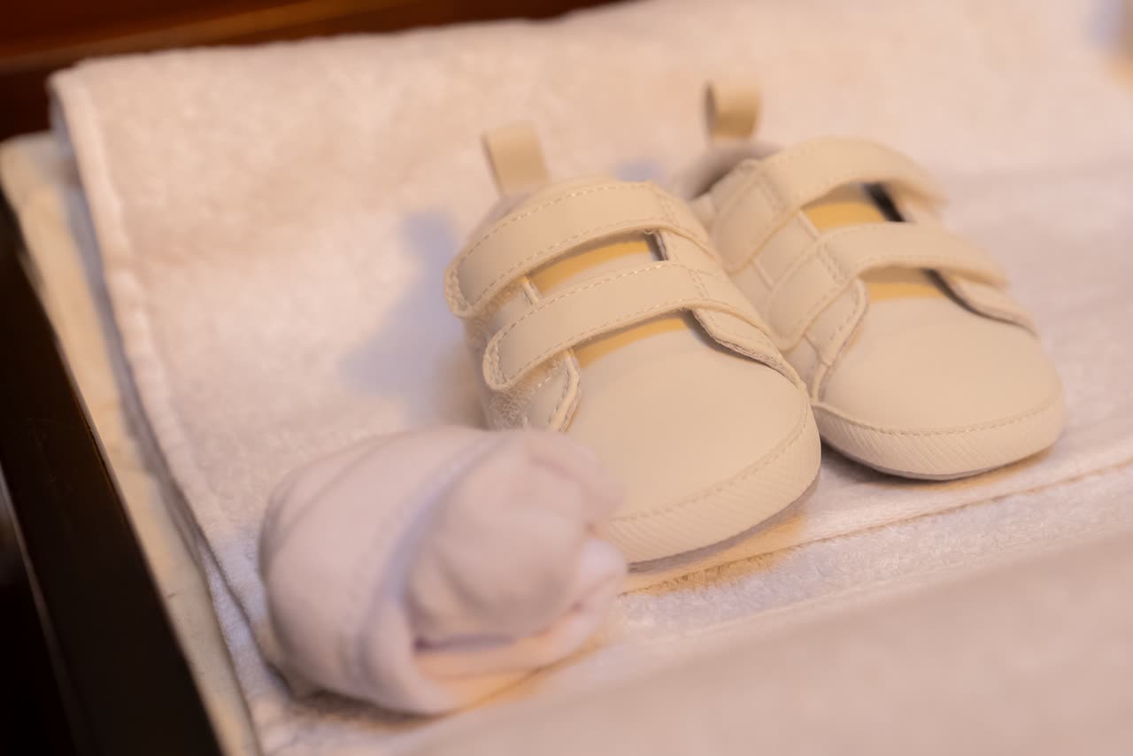 Baby shoes photographed as part of christening preparation details
