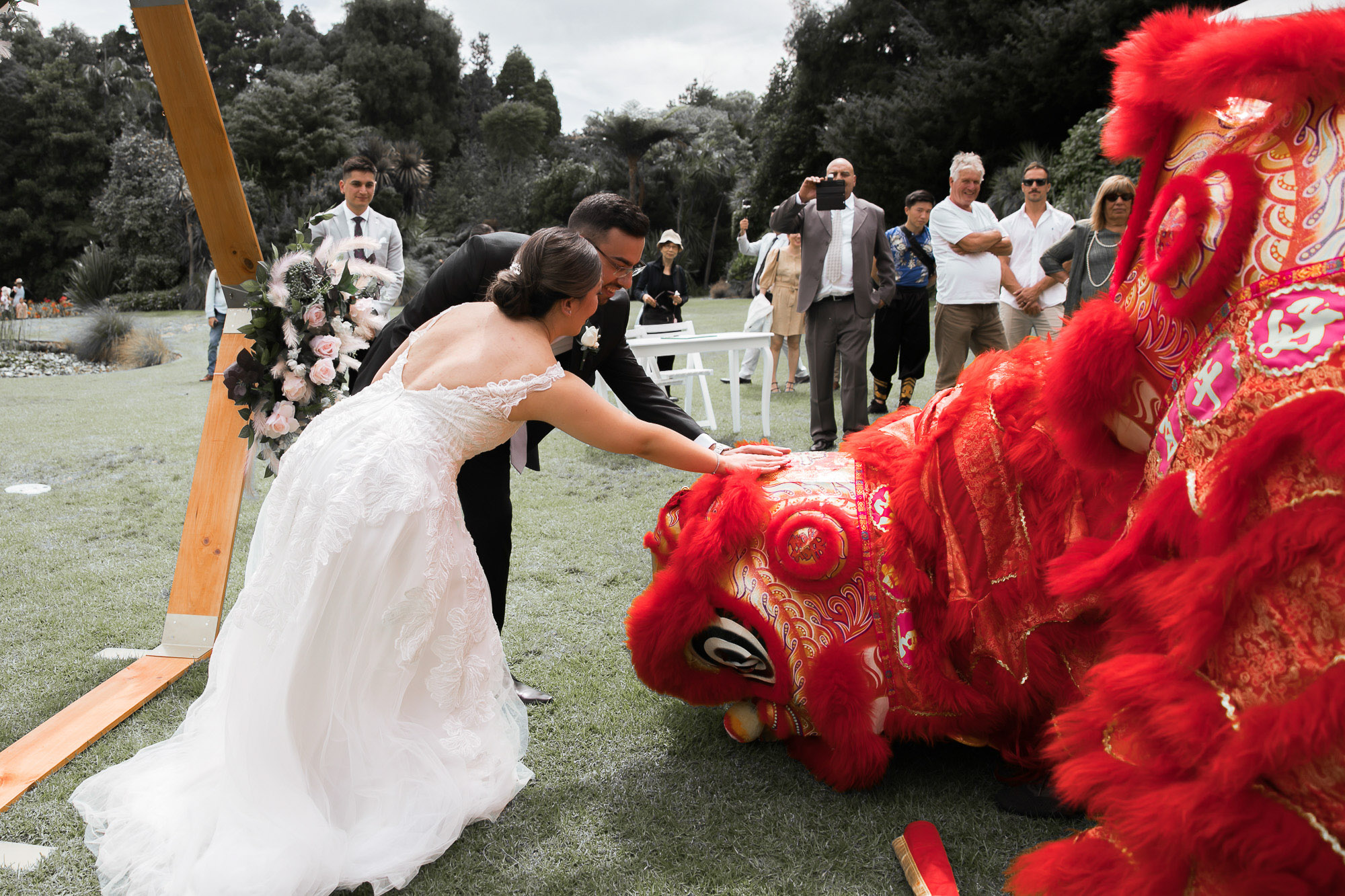 A Melbourne wedding couple with a Chinese dragon during their celebration, photographed by Royale Photography.