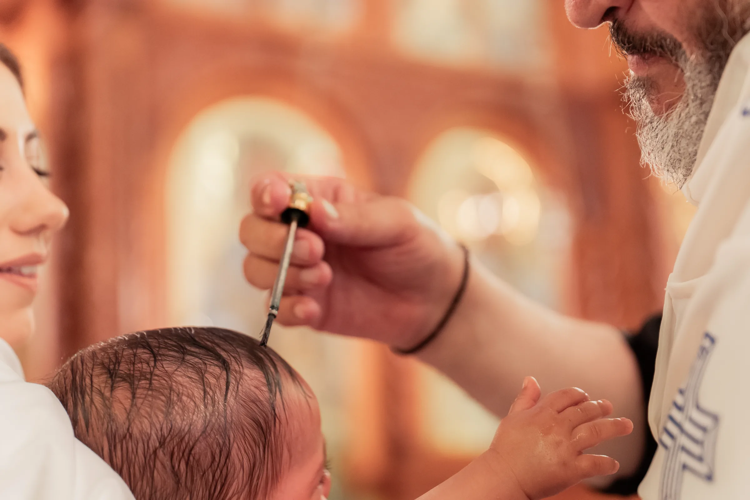 Priest blessing during a christening photographed by Royale Photography