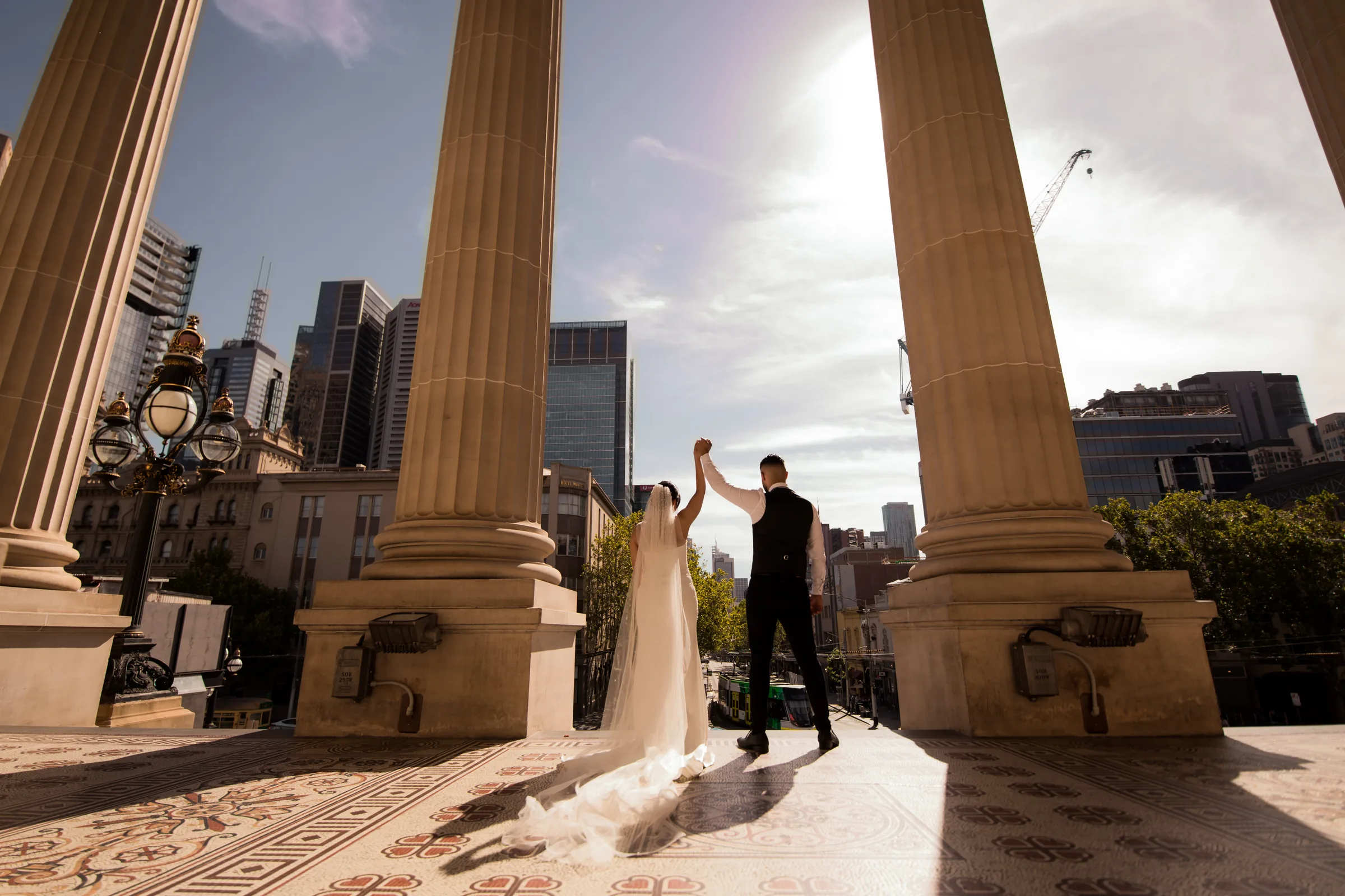 Wedding couple beneath city arches photographed by Royale Photography