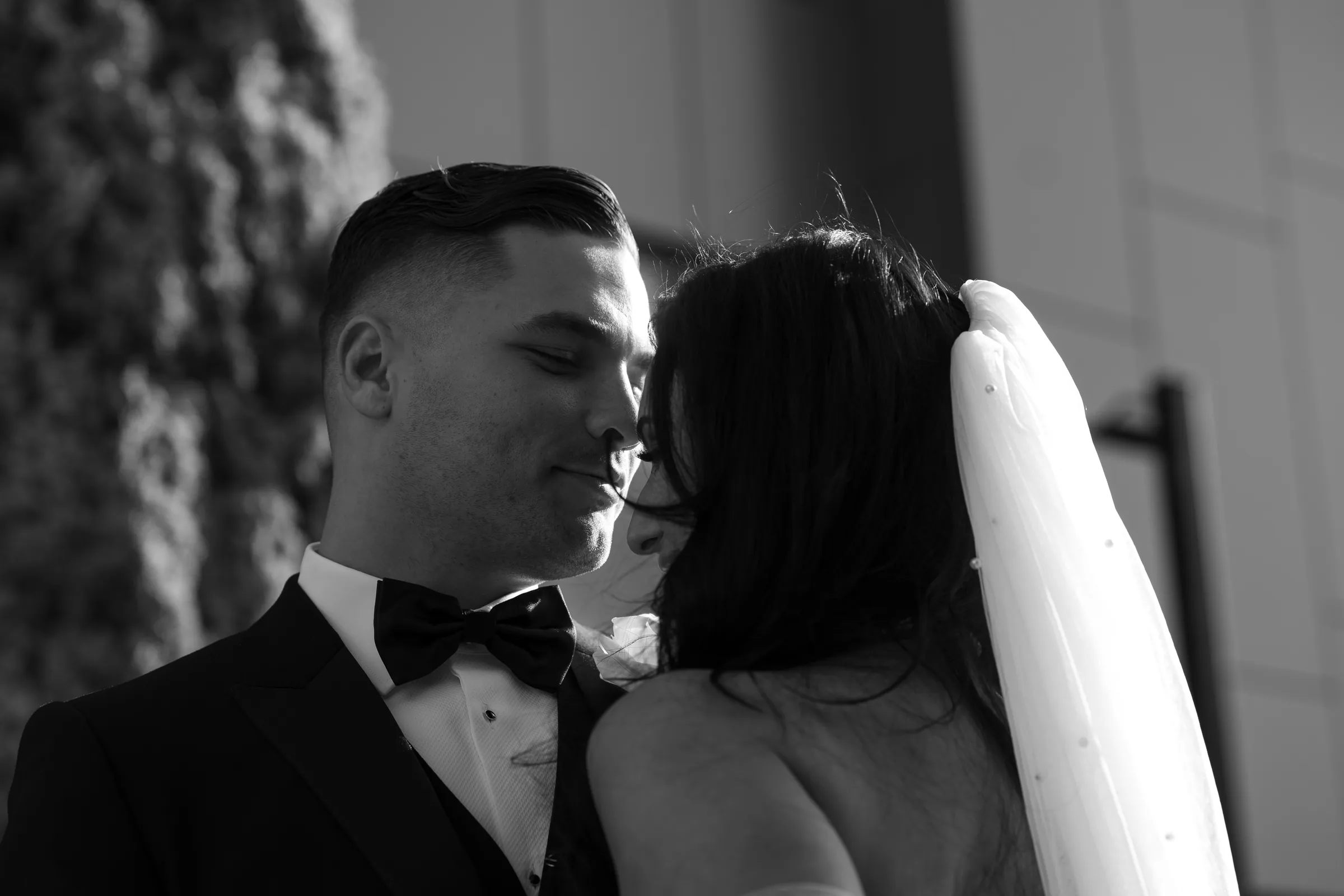 Black and white close portrait of a bride and groom the moment before a kiss, photographed by Royale Photography.